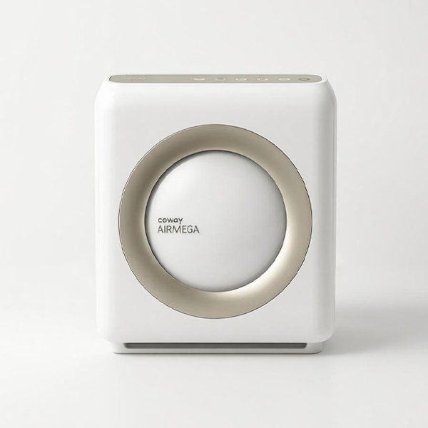 Front view of the box-shaped Coway Airmega 1512HH in white. Key features include a large circular air intake in the center bordered by a champagne gold ring, and a control panel with buttons located on the top edge.