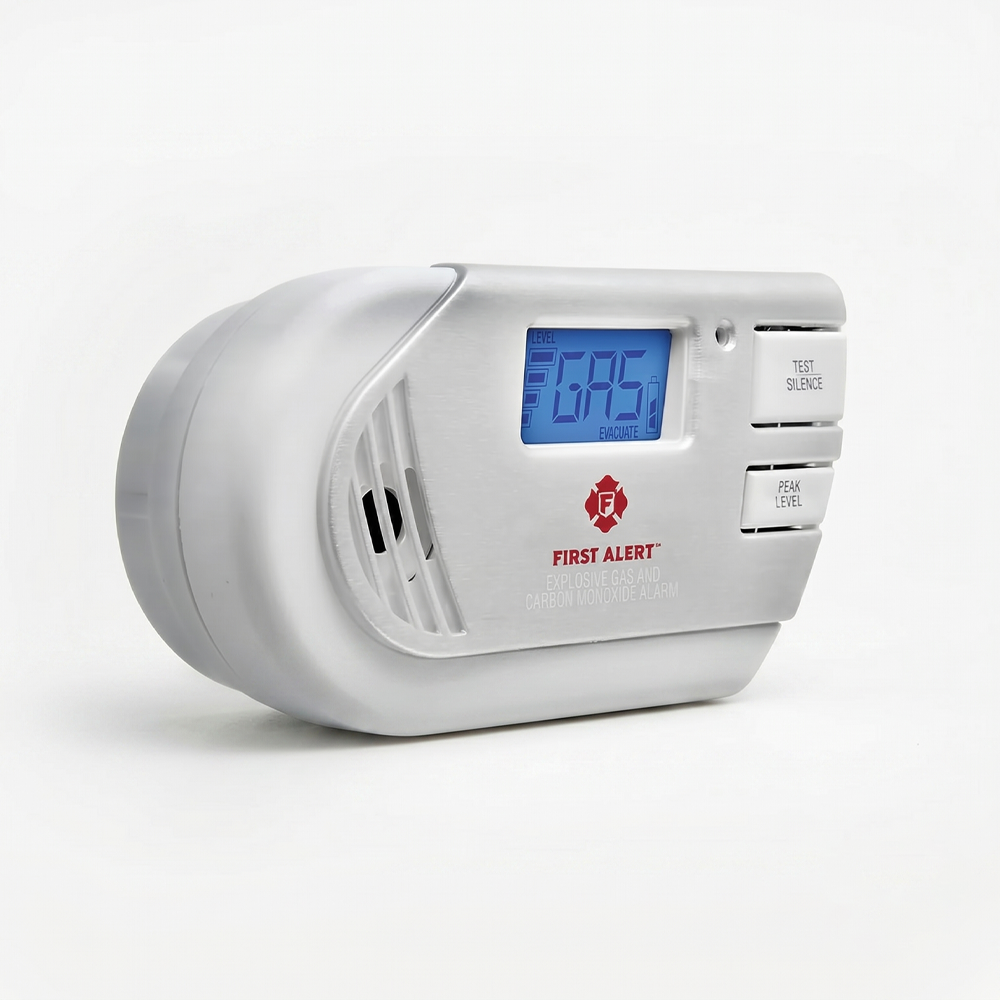 A white First Alert brand plug-in explosive gas and carbon monoxide alarm featuring a blue backlit LCD digital display (showing the word "GAS"), placed on a white seamless background in a professional photo studio with soft lighting.
