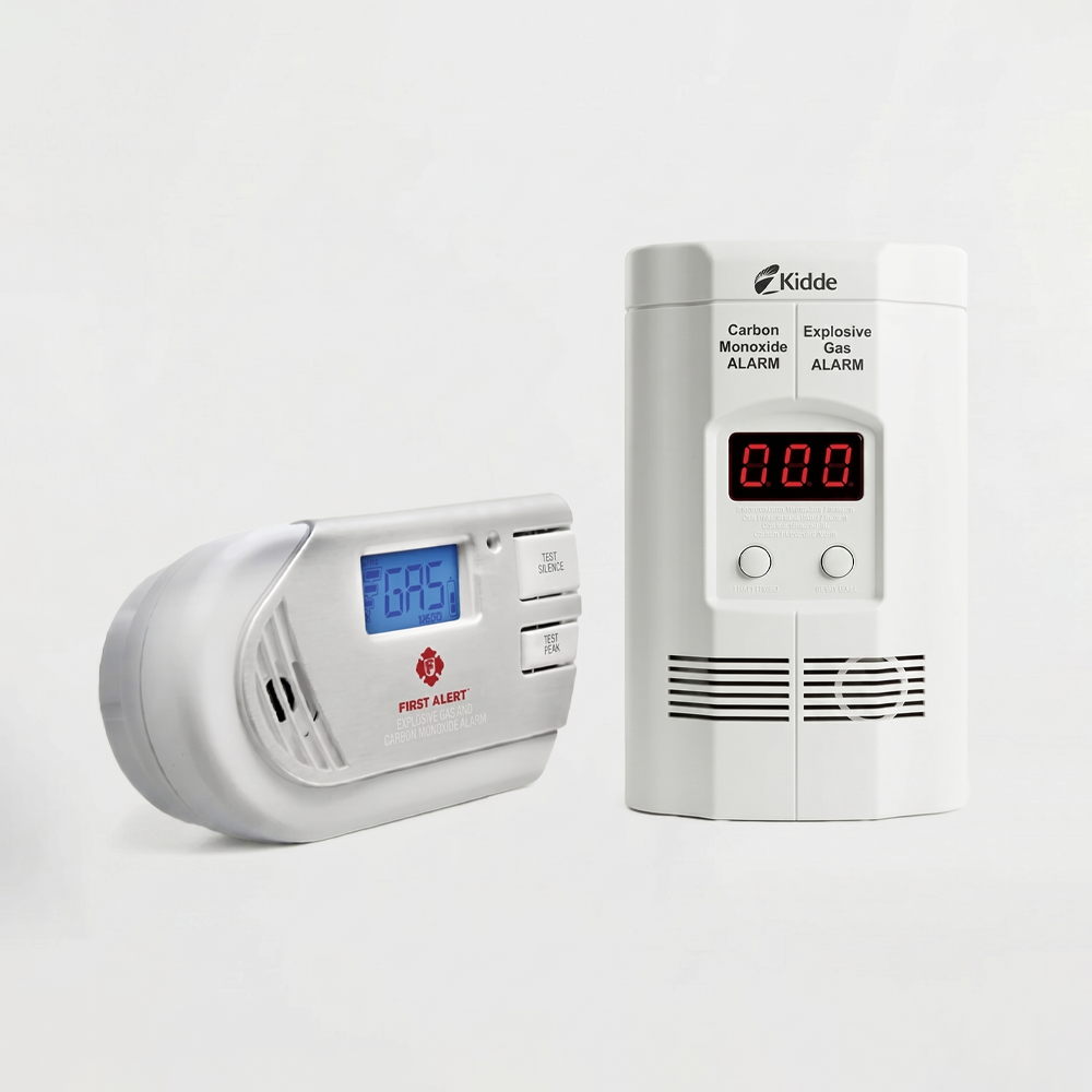 A side-by-side comparison of the First Alert GCO1CN and Kidde KN-COEG-3 combination carbon monoxide and explosive gas detectors on a white studio background, tested for DontPickIt's 2026 home safety review.